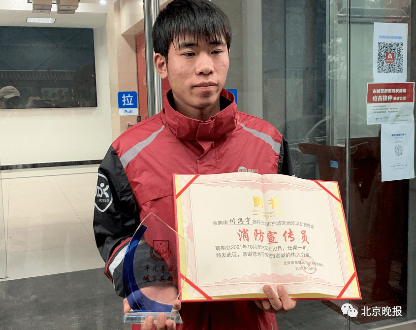 雨中为消防车疏导交通，北京一快递小哥被授荣誉奖杯
